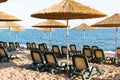 empty sandy beach with sun loungers and a canopy, beautiful blue calm sea Royalty Free Stock Photo