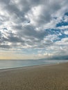 Empty sandy beach under dramatic cloudy sky and calm sea Royalty Free Stock Photo