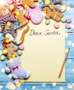 Empty Santa letter with Christmas traditional ginger cookies around it on wooden background. Christmas or New Year holiday