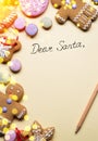 Empty Santa letter with Christmas traditional ginger cookies around it on wooden background. Christmas or New Year holiday