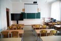 Empty school classroom with desks, chairs, blackboard, projector and large TV. Preparing for the start of the school year and Royalty Free Stock Photo