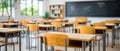 Empty school classroom with desks and chairs set for use. The light and shadows create a welcoming back to school scene Royalty Free Stock Photo