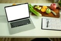 Empty screen Laptop computer with fruit and vegetable on chopping board with Nutrition Facts on table. Royalty Free Stock Photo