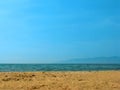 Empty sea beach background. Low horizon with sky and yellow sand. Silhouette of the mountains