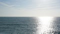 Empty sea to the horizon, daytime. Visible light path on the water.