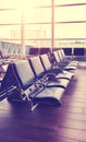 Empty seats in an airport departure hall at sunset, color toned picture, selective focus