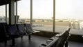 Empty seats of departure lounge airport, view of runway through window, travel Royalty Free Stock Photo