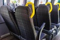 Empty seats with yellow handles in a minibus