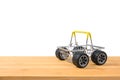 An empty shopping basket with wheels stands on a wooden board on a white background.