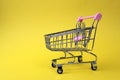Empty shopping cart stands on yellow background Royalty Free Stock Photo