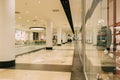 Empty shopping mall corridor with storefront displays and indoor lighting Royalty Free Stock Photo