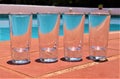 Empty shot glasses next to swimming pool detail Royalty Free Stock Photo