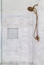 A custom tiled shower with a gold shower head.