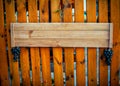 Empty signboard made of planks hanging on a wooden fence.