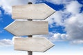 Wooden signpost with three arrows, sky in background Royalty Free Stock Photo