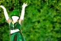 Empty Silhouette of a girl that dress a green cap that dances on Green Background with golden cascade of lights fot saint patrick