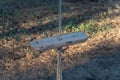 Empty single-rope swing on a rope. Wooden swing and rope with a knot. Close-up. Selective focus Royalty Free Stock Photo