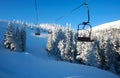 Empty ski chairlift in winter mountain above resort slopes