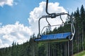 Empty ski lift on a background of forest and blue sky. Holidays in mountains in summer. Ecotourism Royalty Free Stock Photo