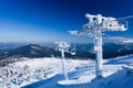 Empty ski lift covered with frost and snow with mountains at background Royalty Free Stock Photo