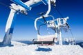 Empty ski lift covered with frost and snow with mountains at background Royalty Free Stock Photo