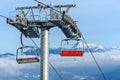 Empty ski lift in a ski resort with a beautiful view of snowy mountains in the background Royalty Free Stock Photo