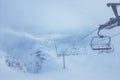 Empty ski lifts among snow-covered mountains and snowdrifts,ski slopes are not cleared and not ready for tourists Royalty Free Stock Photo