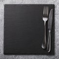 Empty slate stand and cutlery on the table. Food background