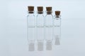 Empty small glass transparent flask bottles sealed with wooden stoppers. Objects are reflected on the surface as in a mirror.