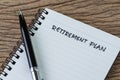 Empty small notepad with pen and handwriting headline as Retirement Plan on wood table in soft vintage tone, planning for saving