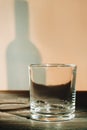 Empty small shot glass and shadow of bottle.