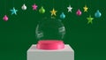 Empty snow glass ball with pink tray on white podium on green canvas background with hanging colorful balls and stars ornaments.