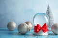 Empty snow globe with red bow and Christmas decorations on table. Royalty Free Stock Photo