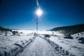 Empty snowy road and shining sun