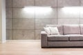 Empty sofa against illuminated wall in apartment