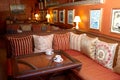 Empty sofa with red pillows and wooden table in coffee shop. Old antique furniture, shabby chic exterior. Vintage style