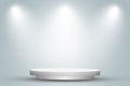 Round white podium or pedestal in studio room with spotlight in gray background.