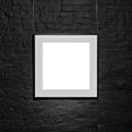 Empty square frame on black brick wall. Blank space poster or art frame waiting to be filled. Square Black Frame Mock-Up Royalty Free Stock Photo
