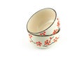 Empty stack beige ceramic bowl with brown rim and red flora pattern isolated on a white background.