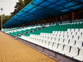 empty stadium stands, plastic seats of different colors under a blue canopy Royalty Free Stock Photo