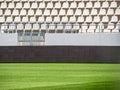 Empty stadium with white chairs in tribune and the green lawn grass Royalty Free Stock Photo