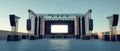 An empty stage with a large screen and speakers set up outdoors ready for a concert or show