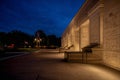 Empty stone bench beside illuminated classical building at night Royalty Free Stock Photo