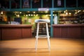 an empty stool on a comedy club stage