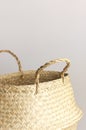 Empty straw wicker basket on a gray background. Fashionable bamboo basket, stylish interior item, eco design, handmade. Natural Royalty Free Stock Photo