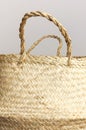 Empty straw wicker basket on a gray background. Fashionable bamboo basket, stylish interior item, eco design, handmade. Natural Royalty Free Stock Photo