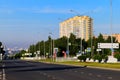 Empty street of the city with traffic lights and traffic signs against the background of three tall houses with an empty sign Royalty Free Stock Photo