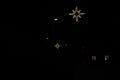Empty street at night. There are only street lanterns glowing in the darkness and Christmas star shaped bright glowing decoration.