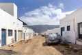 Empty street with sand and white houses in Caleta de Sebo on the island La Graciosa