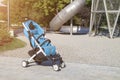 empty stroller stands near modern playground with large metal slide Royalty Free Stock Photo